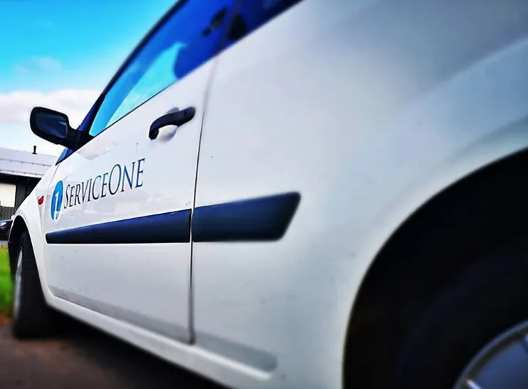 ServiceOnen valkoinen auto, jonka kyljessä on yrityksen logo