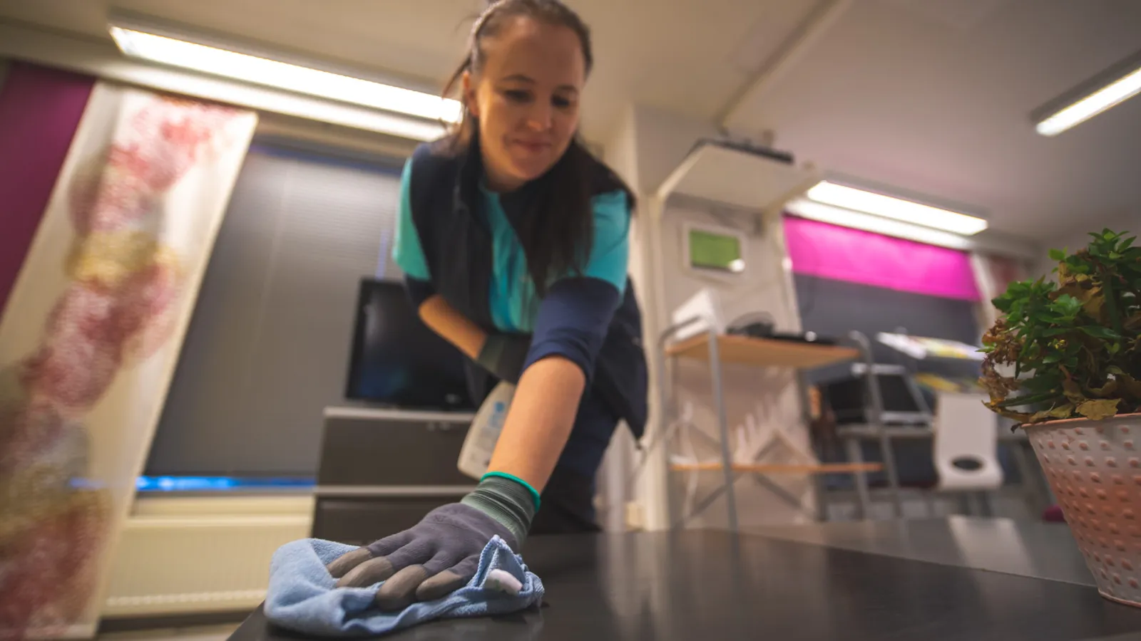 ServiceOnen siivooja pyyhkii pöytätasoa toimistossa